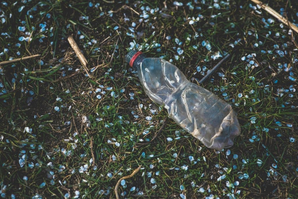 Reducing carbon footprint with virtual solutions a flat plastic bottle on the ground